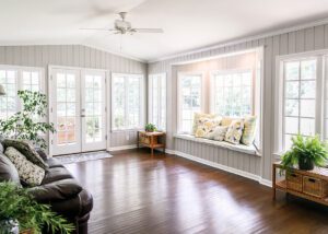 Bright living room addition with large windows, wood floors, and built-in window seat