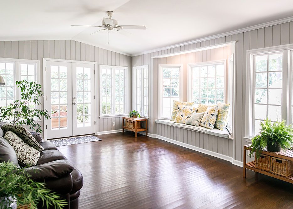 Bright living room addition with large windows, wood floors, and built-in window seat