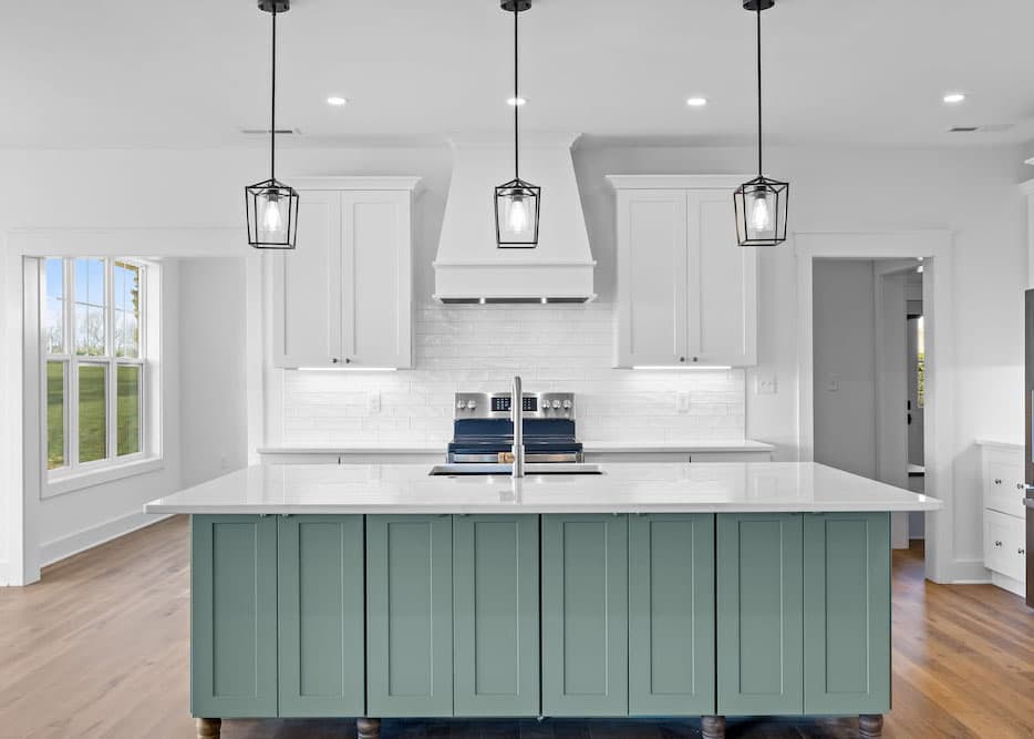 Kitchen with sage green shiplap island, white quartz countertop, white shaker cabinets, custom range hood, subway tile backsplash, and black lantern pendant lights